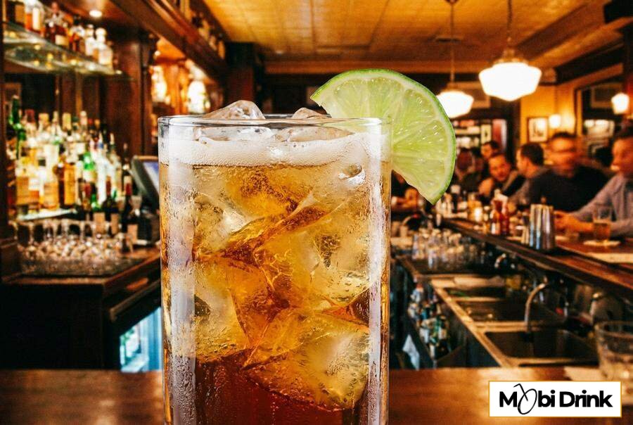 Szklanka z drinkiem Ballantines z colą i limonką