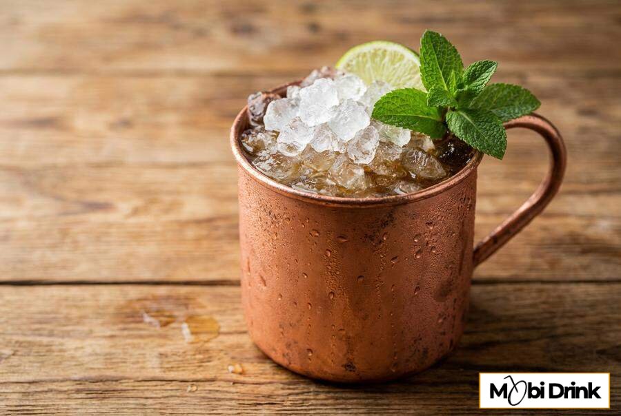 Miedziany kubek z drinkiem Jäger Mule i limonką