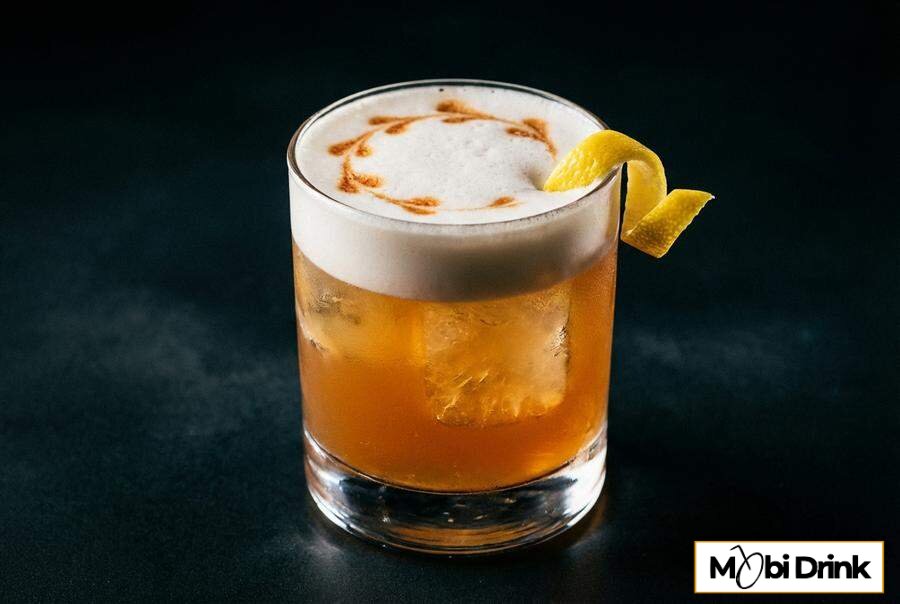 Klasyczny drink Whisky Sour z pianką i bittersem w szklance