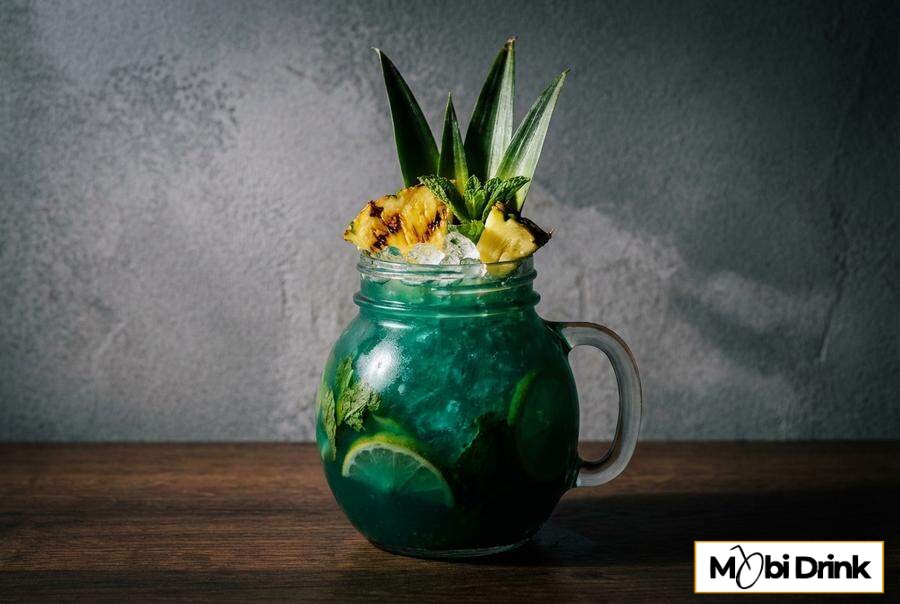 Turkusowy drink Sweet Poison z dekoracją z ananasa