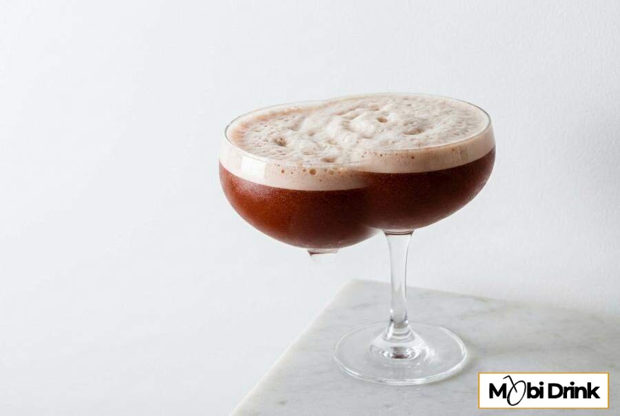 Ciemny drink Trinidad Sour z pianką w kieliszku