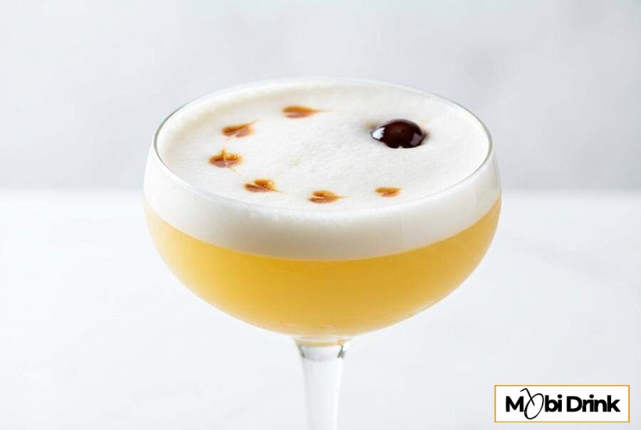 Koktajl Whiskey Sour z pianką i wisienką.