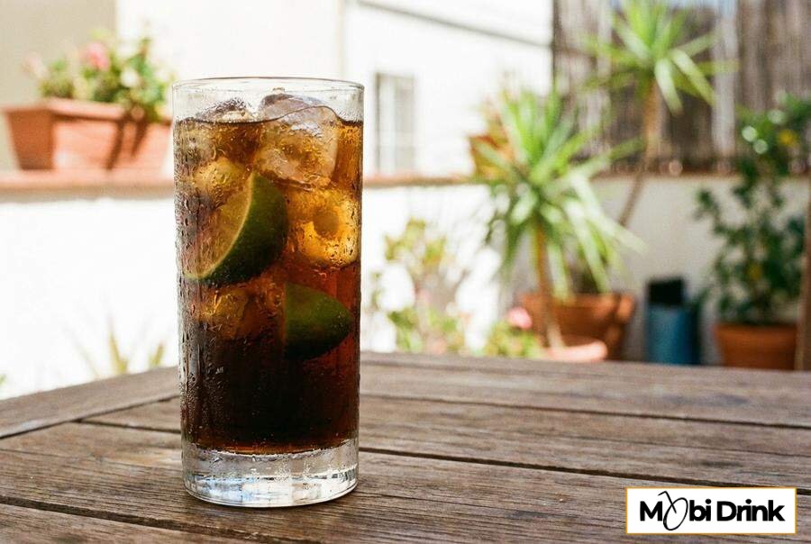 Orzeźwiający drink whisky z colą i cząstkami limonki